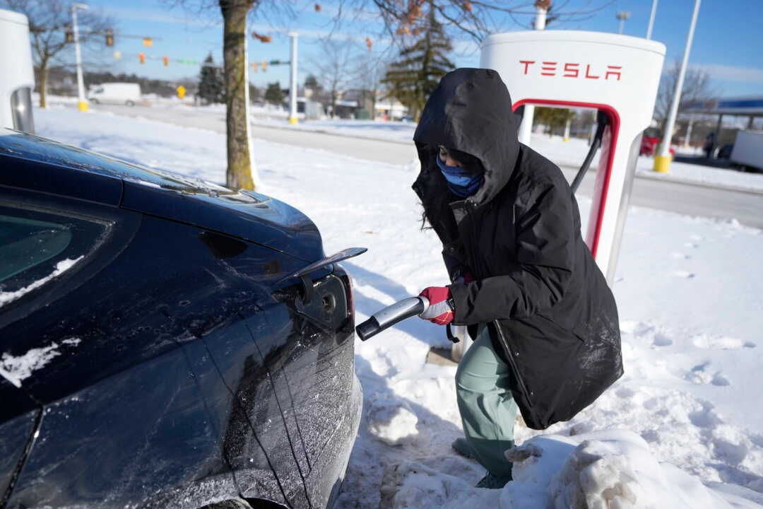 A woman prepares to charge her Tesla in Ann Arbor, Michigan, on Jan. 17, 2024. A cold snap across the United States and Canada has exposed a big vulnerability for electric vehicle owners. (AP Photo/Carlos Osorio)